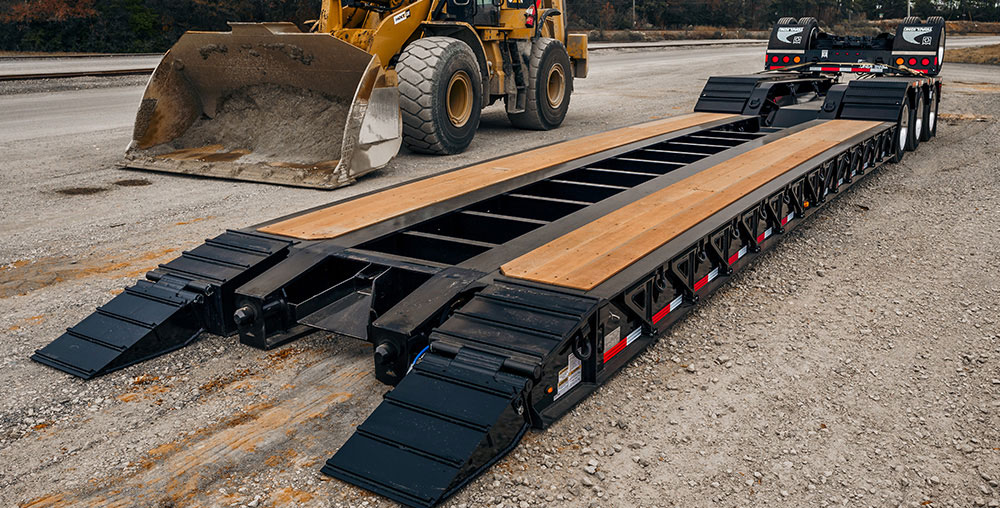 Lowboy trailer hauling heavy oversized machinery